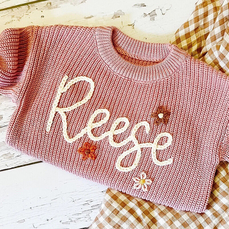 Suéter hecho a mano personalizado con nombre con flores multicolor y texto blanco para bebé