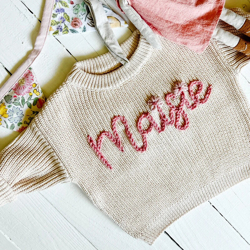 Suéter hecho a mano personalizado con nombre con encantadoras flores y texto rosa para bebé