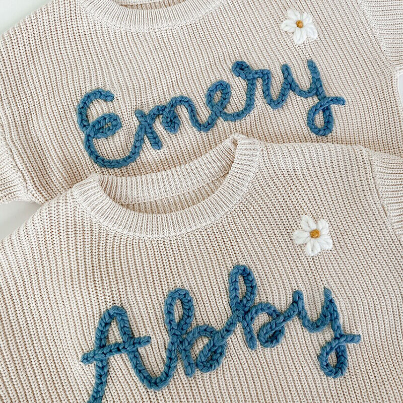 Suéter hecho a mano personalizado con nombre con flores blancas y texto azul elegante para niños